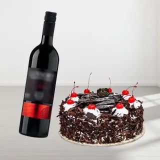 black forest cake with bottle of red wine 