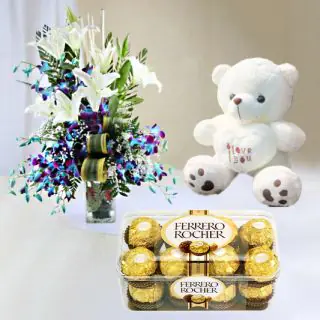  beautiful vase arrangement of lilies and orchids with 16 pcs ferrero rocher chocolate & 6 inch teddy bear 