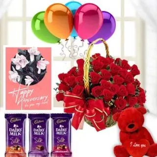 Basket of 25 red roses, 1 feet height red teddybear, 3 dairy milk silk chocolates,  anniversary Greeting card with 5 blown balloons 