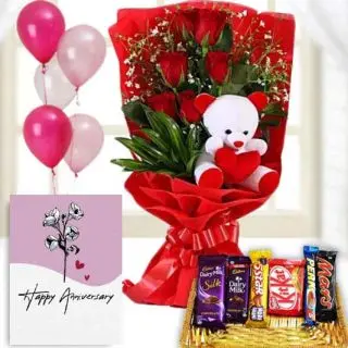 Bunch of 6 red roses with 6 inch teddybear sitting in it , Basket of assorted chocolates,  anniversary Greeting card with 5 blown balloons