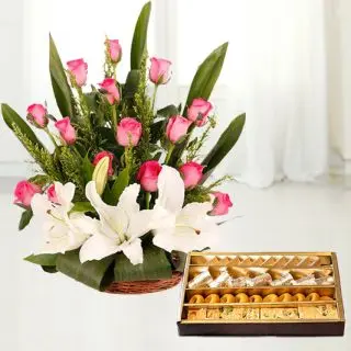 Basket arrangement of white lilies with pink roses with 1 kg assorted sweets