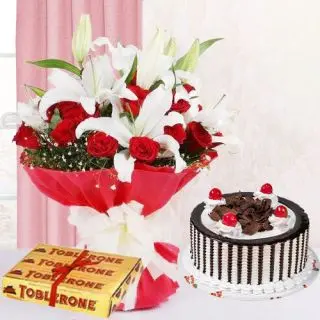 Bunch of red roses & white lilies with chocolate truffle cake with set of 3 toblerone chocolates 