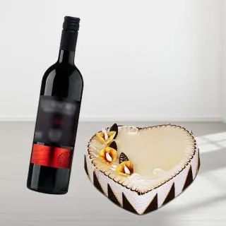 heart shape butterscotch cake with bottle of red wine