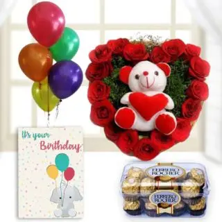 Heart shape arrangement of 15 red roses with teddybear sitting in it, 16 pcs rocher ferrero chocolates, birthday Greeting card with 5 blown balloons 