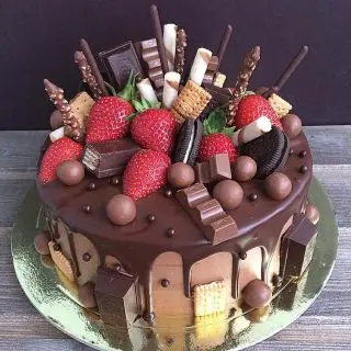 premium chocolate explosion anniversary cake top up with delicious chocolates , strawberries