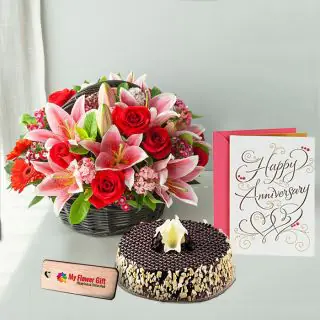 Basket Arrangement of mix exotic flowers with half kg chocolate almond cake with anniversary card 