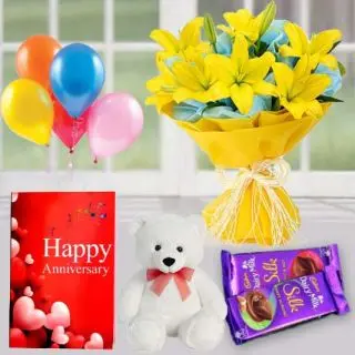 Bunch of 5 yellow lilies, 1 feet height teddybear, 2 dairy milk silk chocolates ,  anniversary Greeting card with 5 blown balloons 