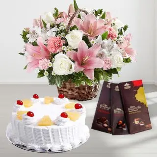 Basket arrangement of white lilies&pink roses with pineapple fresh cream cake with set of 3 bournville chocolates