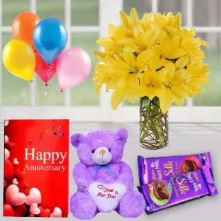 8 Yellow lilies in glass vase,  1 feet height teddybear, set of 2 dairy milk silk, anniversary Greeting card with 5 blown balloons 