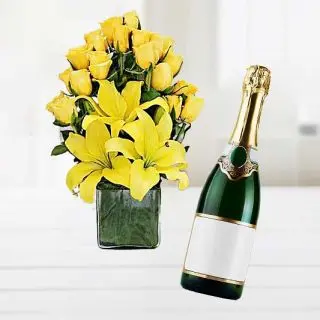 basket arrangement of lilies & roses with bottle of champagne