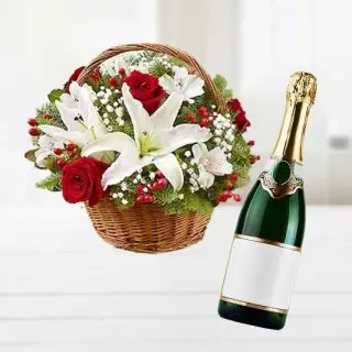 Exotic basket arrangement of lilies and roses with bottle of champegne