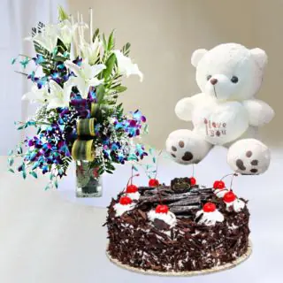 Exotic vase arrangement of blue Orchids with white lilies ,black forest cake with 6 inch teddybear 