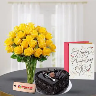 Yellow lilies in glass vase with 1 kg chocolate heart shape cake with anniversary greeting card 