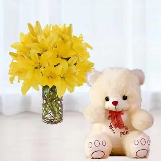 10 yellow lilies in glass vase with 6 inch teddy bear 