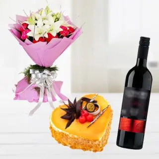 Bunch of white lilies with red carnations with heart shape butterscotch premium quality cake with bottle of red wine 