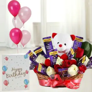 Basket arrangement of 5 roses with 5 dairymilk , with 6 inch teddybear sitting in it,birthday greeting card with 5 blown balloons 