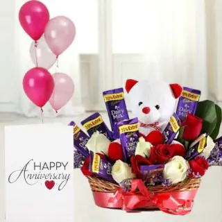 Basket arrangement of 5 roses with 5 dairymilk , with 6 inch teddybear sitting in it, anniversary greeting card with 5 blown balloons 