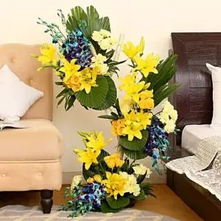 4 feet height Designer Arrangement of 20 yellow lilies, 50 yellow carnations, and 20 blue orchids  