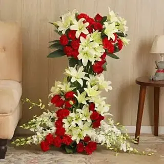 4 feet height Exclusive Arrangement of 15 white asiatic lilies, 20 white orchids with 80 red carnations