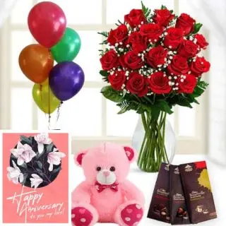 15 red roses in glass vase, 3 bournville dark chocolates,6 inch pink teddybear, anniversary Greeting card with 5 blown balloons 
