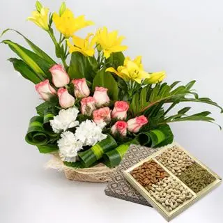 Basket arrangement of lilies and roses with Box of 1 kg assorted dryfruits