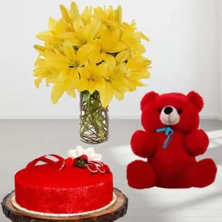 8 yellow lilies in glass vase with red velvet premium quality cake with 6 inch red teddybear 
