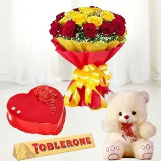 Bouquet of 12 red and yellow roses, 1 feet height cute teddy bear with red velvet heat shape cake with toblerone chocolates 