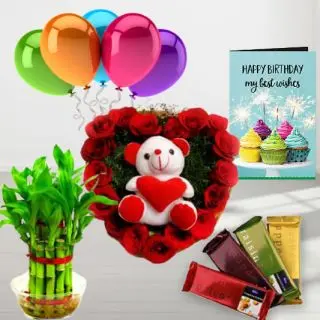 6 inch teddybear sitting in a heart shape arrangement of 15 red roses, pack of 5 perk chocolates, 6 inch height teddy bear, 2 layer Lucky bamboo plant, 5 blown balloons with birthday greeting card