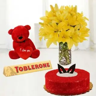 10 yellow lilies in glass vase with 6 inch red colour teddybear with red velvet cake with toblerone chocolates 
