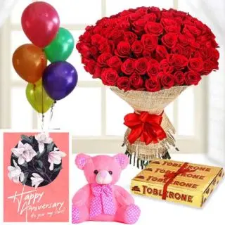 Beautiful Bunch of 100 red roses, 6 inch pink teddybear, 3 toblerone chocolates,  anniversary Greeting card with 5 blown balloons 