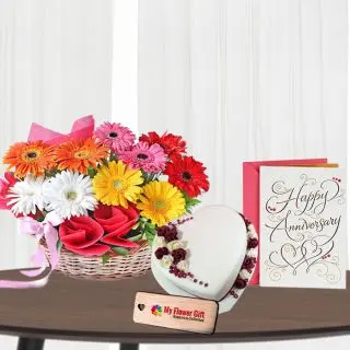 Basket arrangement of mix color gerberas with 1 kg heart shape vanilla premium quality cake with anniversary greeting card 