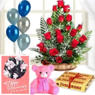 Basket of 20 red roses, 6 inch teddybear,3 toblerone chocolates,  anniversary Greeting card with 5 blown balloons 