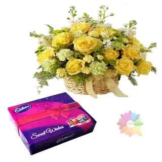Basket arrangement of 12 yellow roses with box of Cadbury celebration