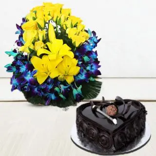 Basket arrangement of blue orchids with yellow lilies, and yellow roses with heart shape dark chocolate cake 