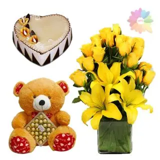 basket arrangement of lilies and roses with heart shape butterscotch cake with 2 feet height teddy bear carrying box of 24 pcs Ferrero Rocher chocolates