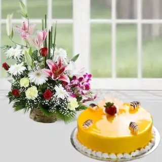 Basket arrangement of lilies, roses, orchids, carnations daisies with mango cool cake 