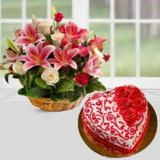 Basket arrangement of pink lilies with red and white roses with heart shape red velvet designer cake 