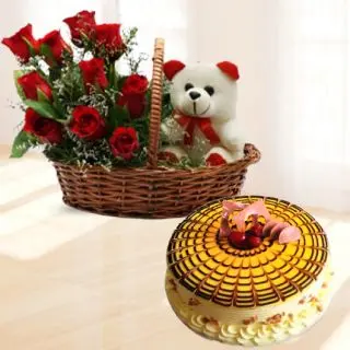 Basket arrangement of red roses with teddy bear sitting in it with butterscotch premium quality cake 