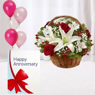 Basket arrangement of red roses with white lilies, anniversary card, 5 blown balloons 