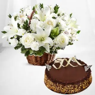 Basket arrangement of white roses with white lilies with chocolate walnut cake 
