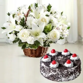 Basket Arrangement of white lilies with roses carnations with black forest cool cake 