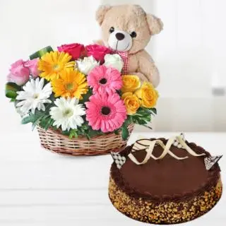 Basket of colourful gerberas & roses with teddybear sitting in it, along with chocolate almond cake