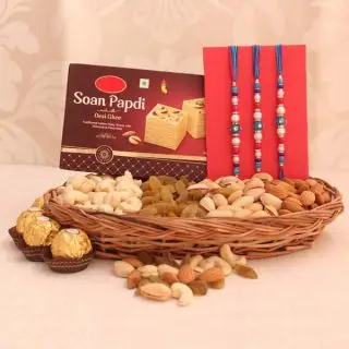 Basket of half kg assorted dry fruits, box of half kg soan papdi, 3 rocher ferrero chocolates, with set of 3 rakhis 