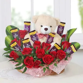 Beautiful basket arrangement of 20 red roses, 6 inch teddybear, with 8 dairy milk chocolates 