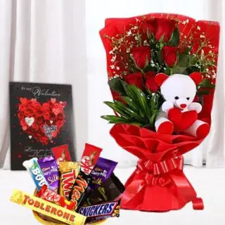 Beautiful bunch of 6 red roses with teddy bear sitting in it, basket of assorted chocolates, with greeting card 