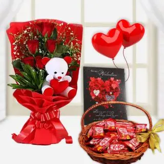 Beautiful bunch of 8 red roses with teddybear sitting in it, valentine day greeting card, basket of kitkat chocolates and pair of heart shape balloons 