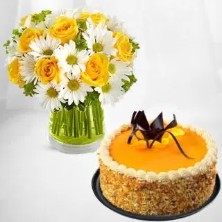 Beautiful vase arrangement of white gerberas, yellow roses with mango cool cake