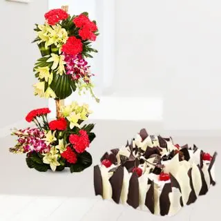 Exclusive 2 feet height arrangement of orchids, lilies, roses, carnations with premium white forest cake 