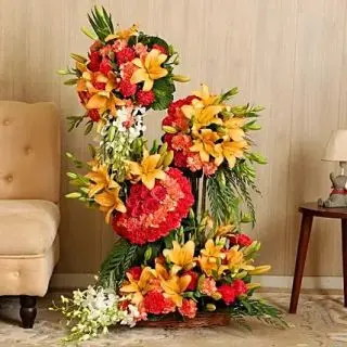 Exclusive 4 feet height arrangement of 15orange  lilies, 80 carnations, 20 white orchids 