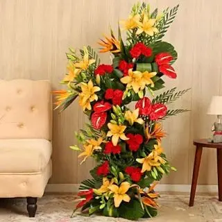 Exclusive 4 feet height Exotic arrangement of Asiatic orange lilies with red carnations and Red anthuriums 